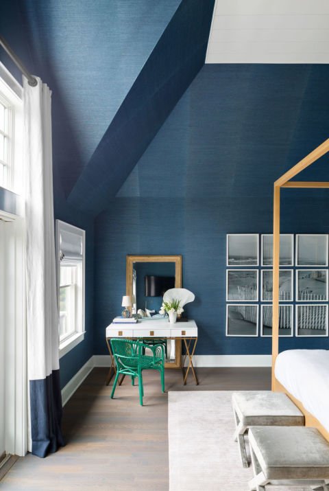 Dormitorio con paredes en color azul, cama con dosel de madera, suelos madera