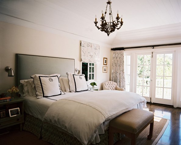 dormitorio blanco con cama y cabecero gris acolchonado, lámpara colgante tipo araña