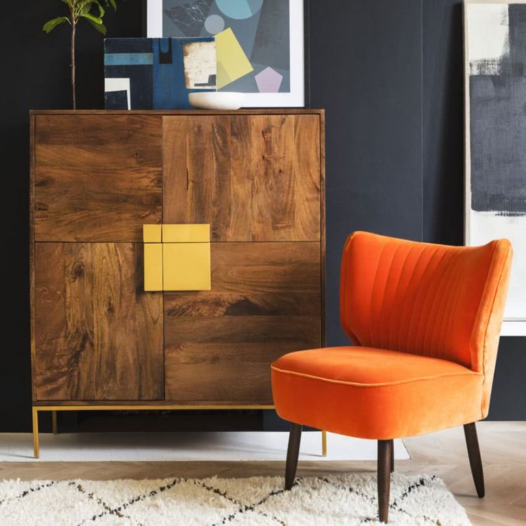 mueble aparador con madera , pared negra y sillón naranja
