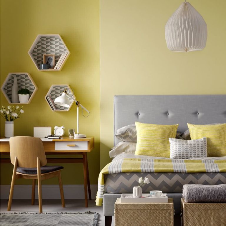 cama en tonos amarillo y gris, paredes amarillas, escritorio de madera clara