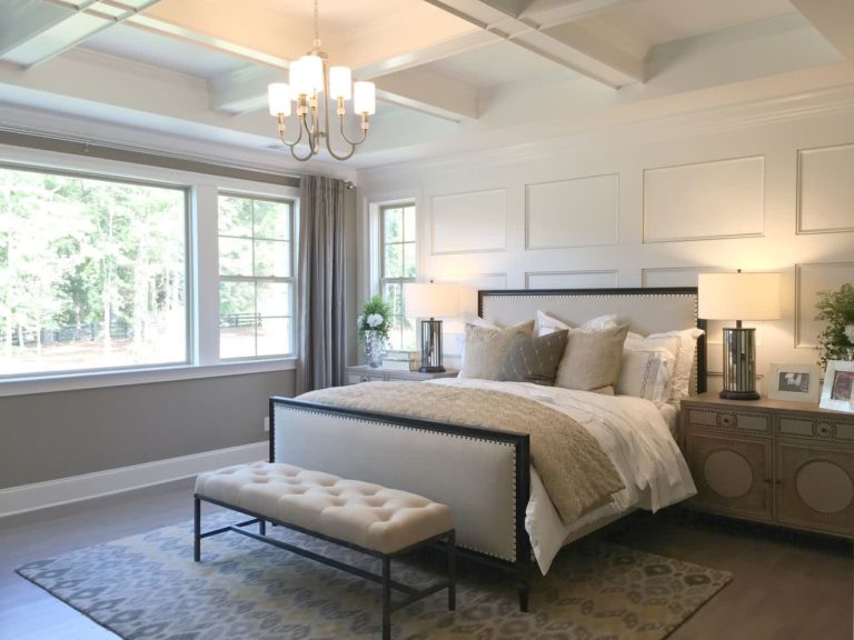 cama con cabecera y pies acolchonado decorados con tachas, paredes blancas
