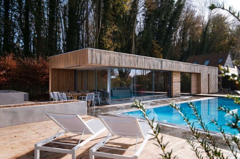 casa de madera y paredes de vidrio, gran piscina con terraza y reposeras