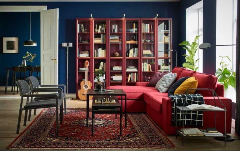 salón con sillón rojo, biblioteca borgoña y paredes azul oscuro