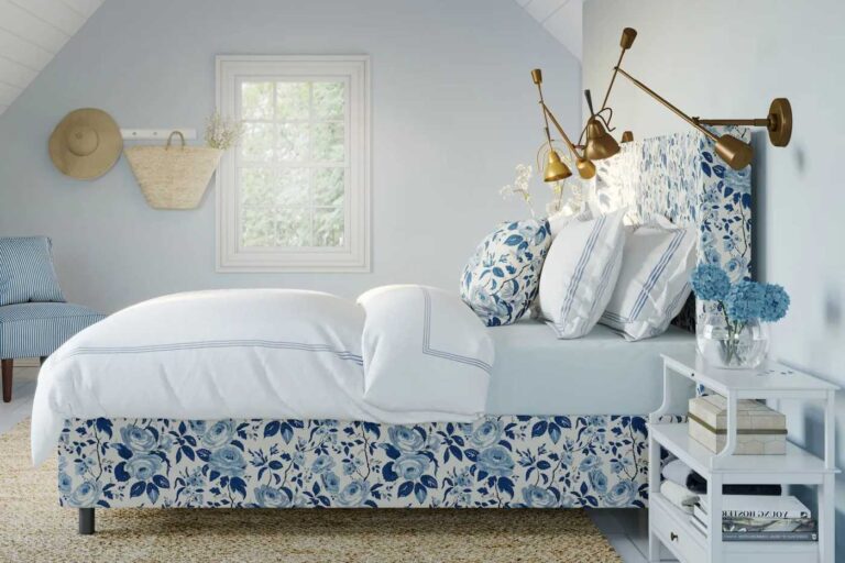 cama forrada con estampado en flores pequeñas en tonos de azul y blanco, paredes blancas
